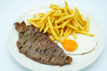 Plato combinado de bistec de ternera con patatas y huevo frito