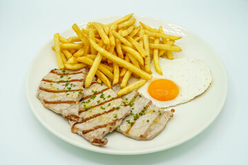 Plato combinado de lomo de cerdo con patatas y huevo frito