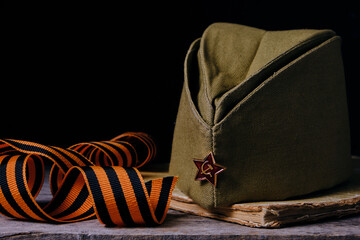 Cap with red star soldiers Red army, an old battered book and a St. George ribbon.Victory Day...