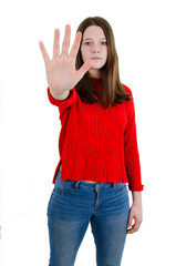 Stop gesture. Strict teenage girl in red sweater raises hand, free space. Stop hand of child, sign...