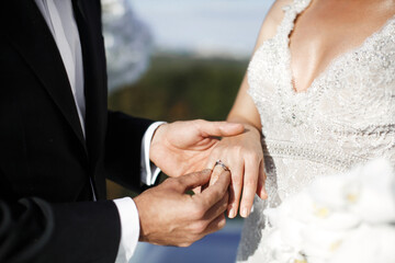 Obraz na płótnie Canvas Groom wears ring on bride's finger