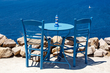 A restaurant table on the seashore awaits guests.