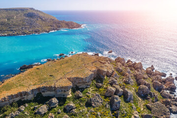 Rocky island from a height and in the distance the land coast before sunset.