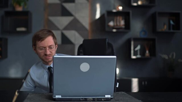 Angry businessman smashes laptop with baseball bat