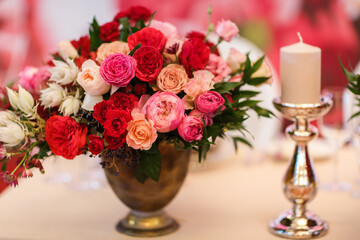 Bouquet of flowers in vase and candle on the wedding table