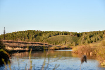 River in spring among reeds and mountainous terrain