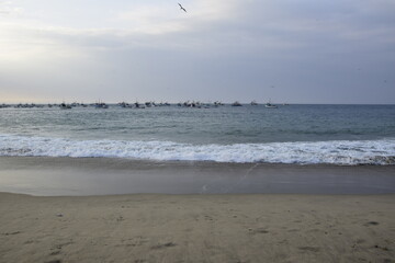 sunset over mancora beach with fisher boats, peru