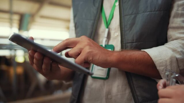 Farmer hands holding tablet computer closeup. Specialists discussing data in pad