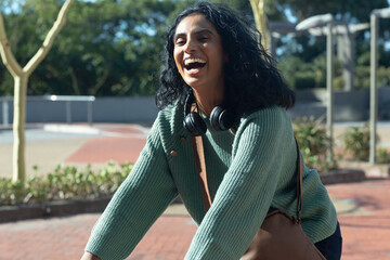 Portrait of cheerful young biracial businesswoman commuting on sunny day