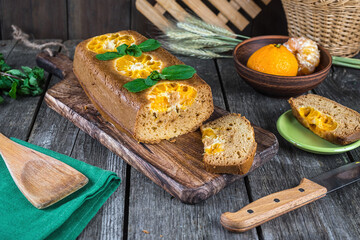 Homemade sweet pie with tangerines, hand made dessert on a wooden table