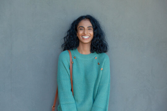 Portrait of happy young biracial businesswoman standing against gray wall with copy space