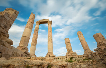 Fototapeta premium unsurpassed view of the ruins of the temple of Hercules on the top of the mountain of the Amman citadel against the background of a blue sky with clouds