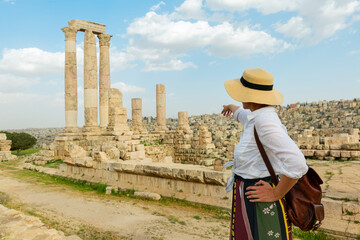 Amman, jordan. travel tourism holiday background -young girl with hat standing pointing to  the...