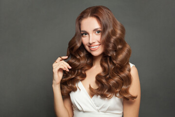 Fototapeta premium Beautiful stylish woman with long wavy brown coloring hair, studio portrait