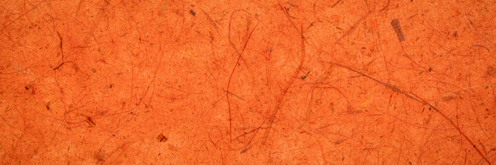 background of amber and orange backlit, handmade, mulberry paper with leaf and fine inclusions, panoramic web banner