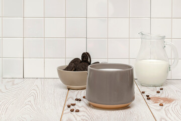 Obraz na płótnie Canvas Latte coffee, cacao, cappuccino with milk in gray cup and sweet cookies in bowl on white kitchen tile background, hot beverage and tasty dessert food close up.mockup, template