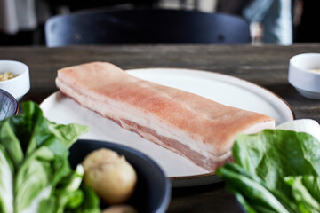 Piece of delicious pork fat on plate in kitchen closeup