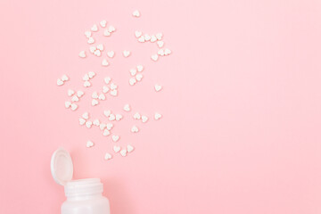 Global Pharmaceutical Industry and Medicinal Products - White Pills or Tablets Scattered from the Pill Container, Lying on Pink Background