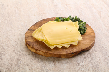 Sliced Gouda cheese over board