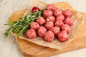 Raw uncooked beef meatballs served rosemary