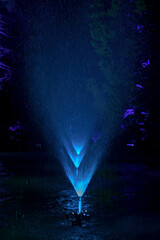 Water fountains with blue light in garden pond