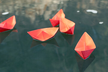 red paper ships on green water