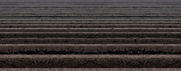 Background with deep plowed straight horizontal furrows in the earth necessary for planting seed...