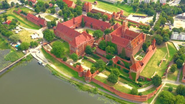 Malbork,Poland.Aerial 4K video from drone to Medieval Malbork ( Zamek w Maborku, Ordensburg Marienburg ),castle in Poland fortress of the Teutonic Knights at the Nogat river in sunrise light.(Series)