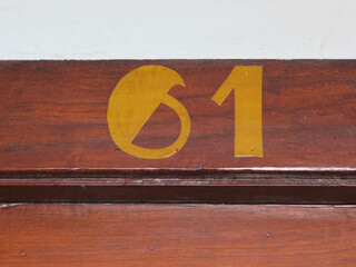 house number 61 painted on a wooden frontdoor