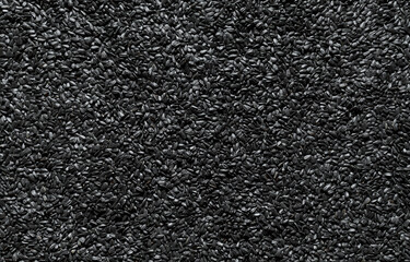 Black sunflower seeds background, above view.