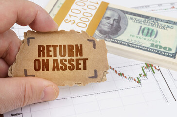 Against the background of dollars and a chart of quotations, a man holds a sign with the...