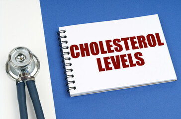 On a blue-white surface lies a stethoscope and a notepad with the inscription - Cholesterol LEVELS