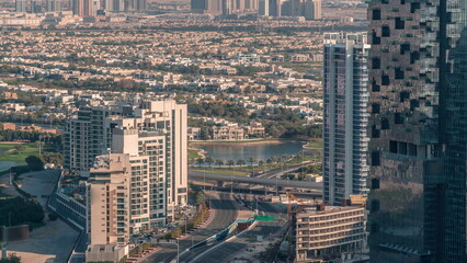 Naklejka na ściany i meble JLT skyscrapers near Sheikh Zayed Road aerial timelapse. Residential buildings and villas behind