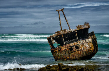 Ship wreck during stormy sea near Cape Agulhas in Republic of South Africa.