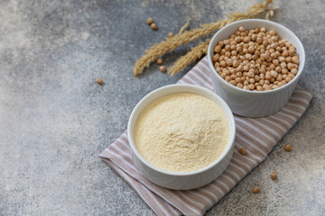 Food and baking gluten-free protein ingredient. Chickpea flour wholesome and raw chickpea over gray stone table. Copy space.