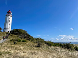 Fototapeta na wymiar The Hiddensee Dornbusch Light House with surrounded green nature and blue sky background