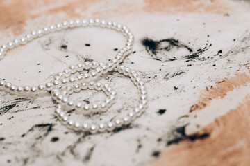 Pearl beads on fabric background pink natural silk marble print.