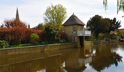 Naklejka premium The river Ouse at Godmanchester with old boathouse and church spire.