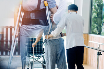 young asian physical therapist working with senior woman on walking with a walker