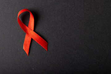 Directly above shot of aids awareness red ribbon isolated against black background, copy space