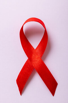 Overhead close-up of red aids awareness ribbon isolated against white background, copy space