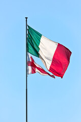 Fototapeta na wymiar Flag of Italy and Flag of Genoa on sky background