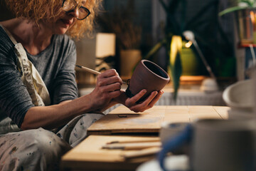 woman carving pottery in her workshop