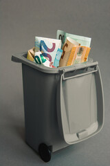 Euro money cash banknotes and coins in the garbage can	