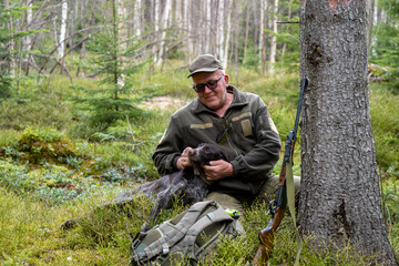 Old Hunter in the woods with his dog. Male hunter hunting with his hunting dog outdoors. German...