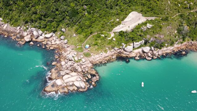 Aerial drone image of rocky mountain, coast of stones near paradise beach with people diving and having fun in natural pools