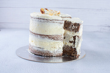 3-tier cake with walnuts and vanilla cream on gray background