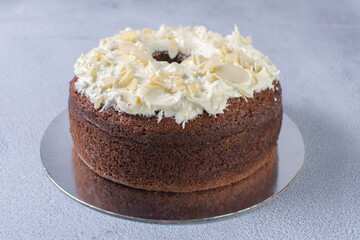 Traditional vanilla cream cake and walnuts on gray background