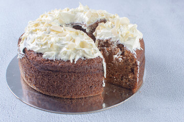 Traditional vanilla cream cake and walnuts on gray background