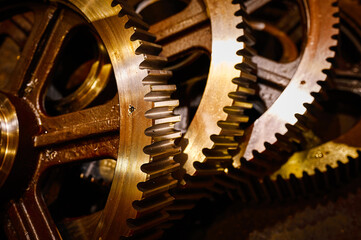 Set of huge cogwheels for spiral gear drive in warehouse - obrazy, fototapety, plakaty